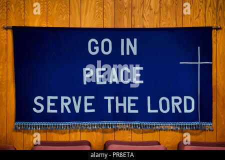 `Go in Peace Serve the Lord` written on Dark Blue Cloth with white cross on the right side, tassels all along the bottom of the cloth. Stock Vector